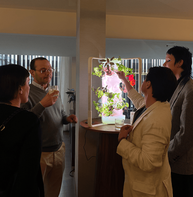 Guests gathered around a glowing Ortus garden at an event